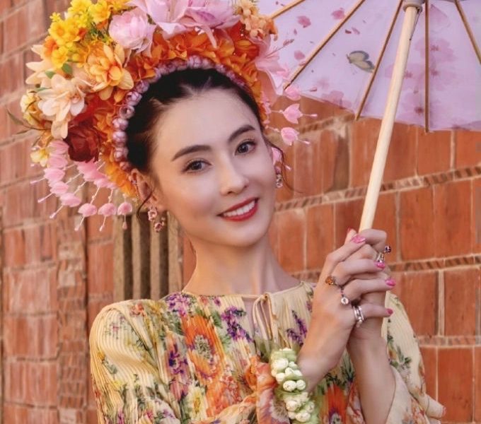 people-woman-smiling-holding-parasol-wearing-flower-headdress-wearing-floral-dress