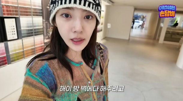 people-A-woman-A-knit hat-A-colorful cardigan-A-paint samples