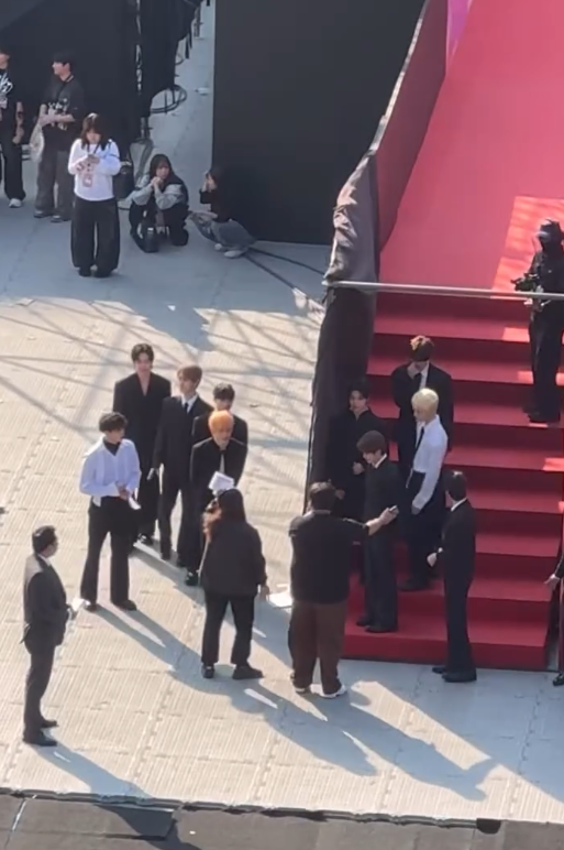 people-group of men in suits-A-red carpet steps-B-staff/security personnel-C-spectators/fans