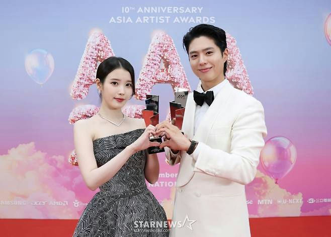people-IU (Lee Ji-eun)-A-Park Bo-gum-B-Asia Artist Awards (AAA) 2022-C-holding trophies-D-hand heart gesture