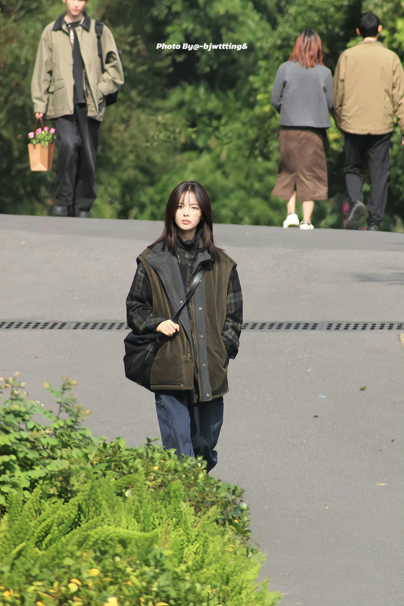 people-woman in foreground-A-outdoor setting-A-autumn fashion-B-carrying bag-B-greenery-C-blurred background-C