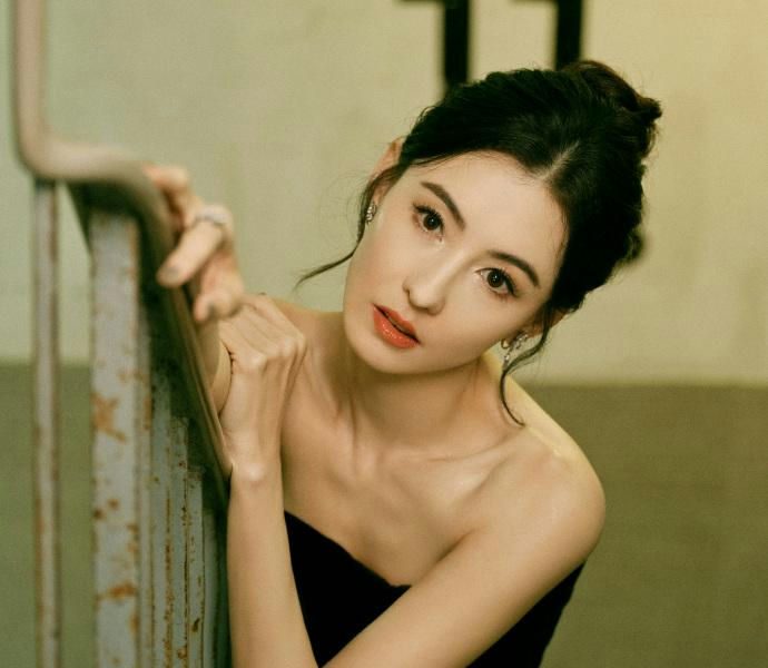 people-woman-A-strapless black dress-A-leaning on railing-A-indoor setting-A-number 11 visible