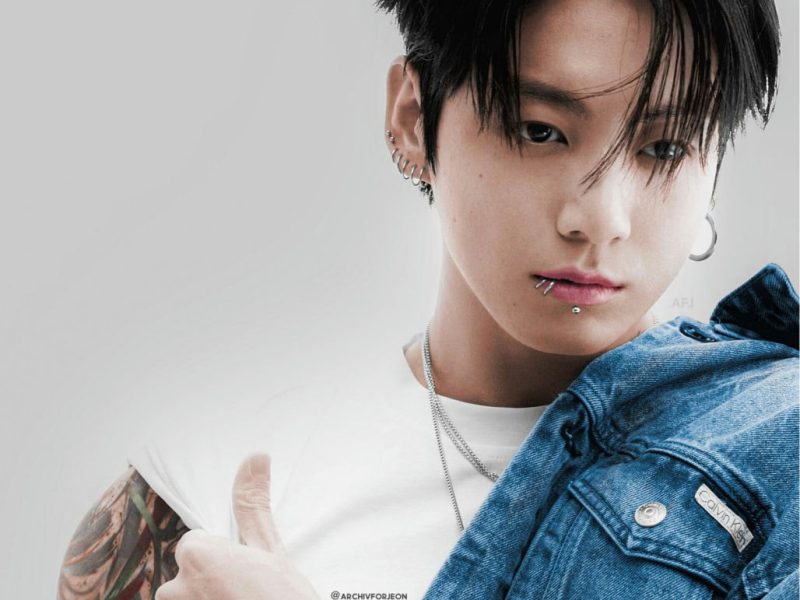 people-Jungkook (BTS)-A-piercings-A-lip piercing-B-tattoos-B-denim jacket-C-thumbs up