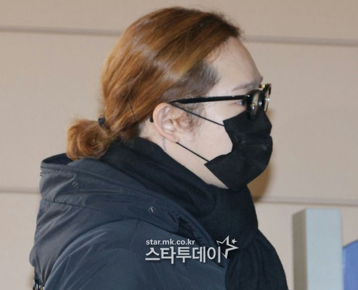 people-one person-side profile-brown hair in a small bun-black glasses-black face mask-black winter jacket