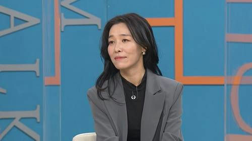 people-woman-A-black hair-A-gray blazer-A-television set-B-interview setting-C