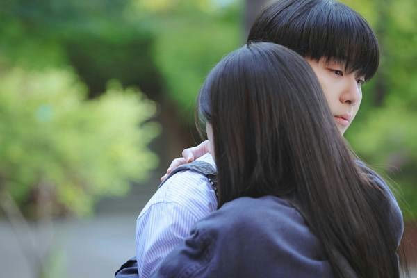 people-Two young people-A-hugging-A-outdoors-A-soft focus background-A-intimate moment
