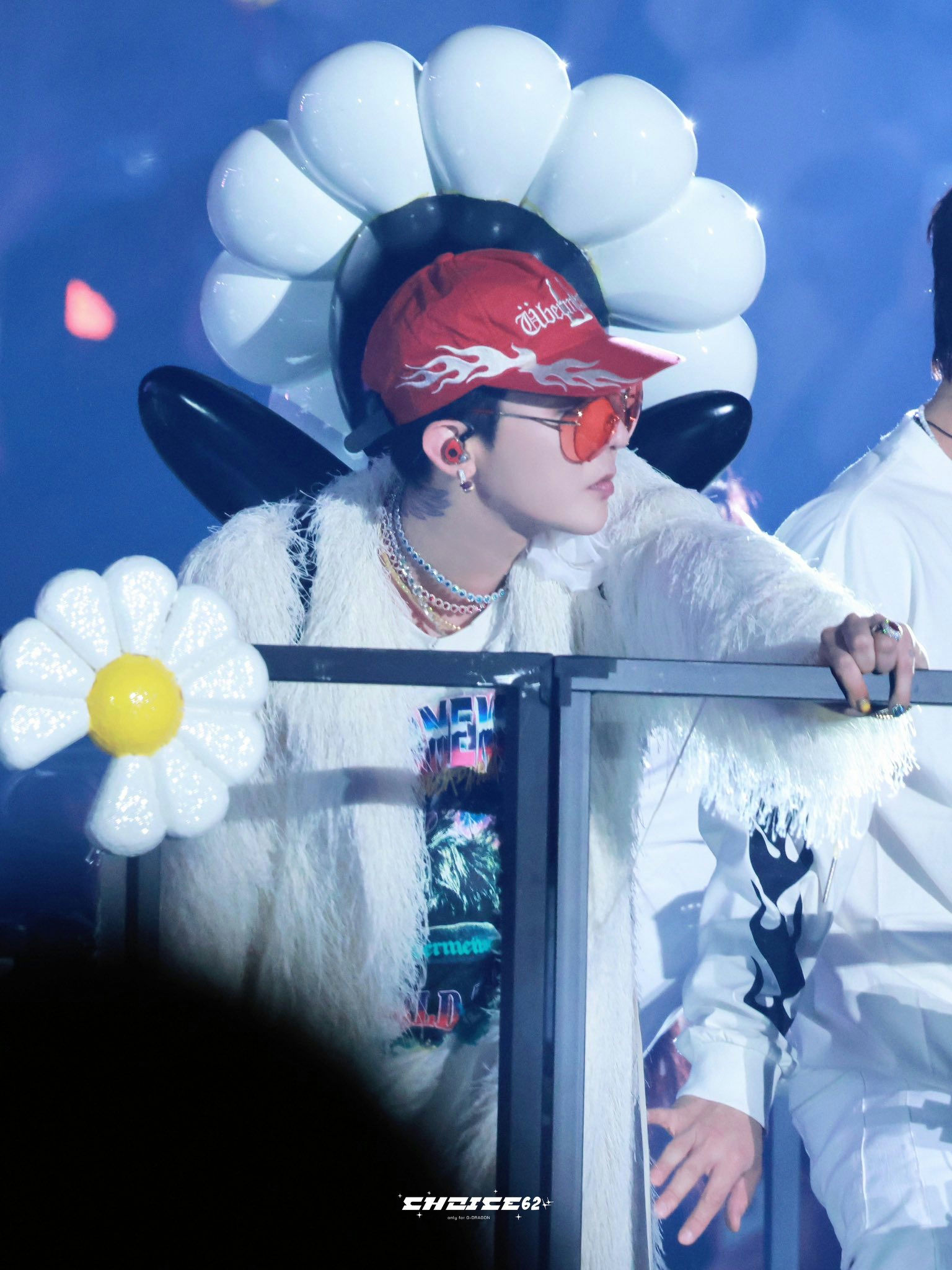 people-Male performer-A-white fluffy coat-B-red flame baseball cap-C-daisy balloon decorations