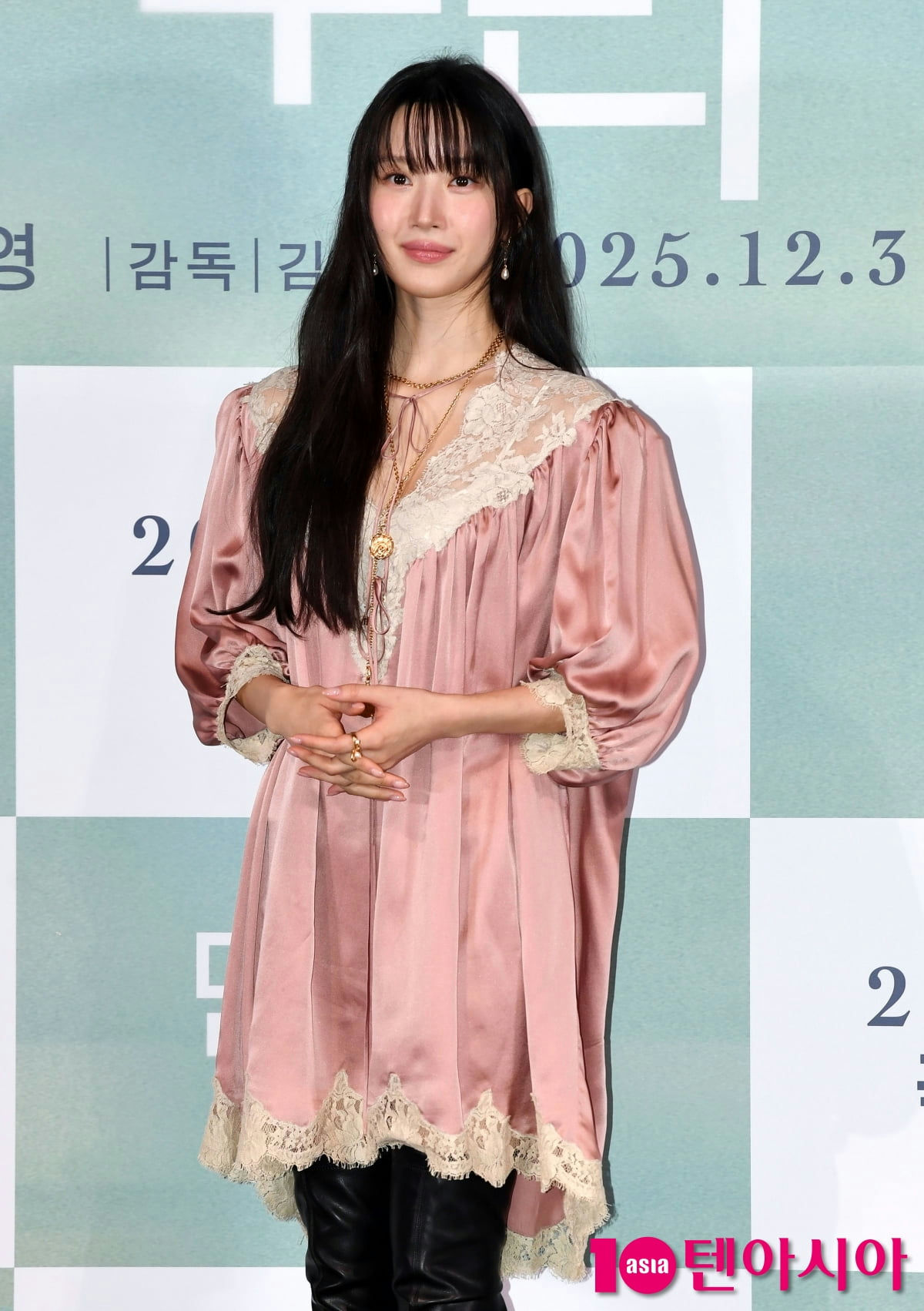 people-A-woman-A-long black hair-A-pink satin dress-A-lace trim-B-gold necklaces-B-black leather pants