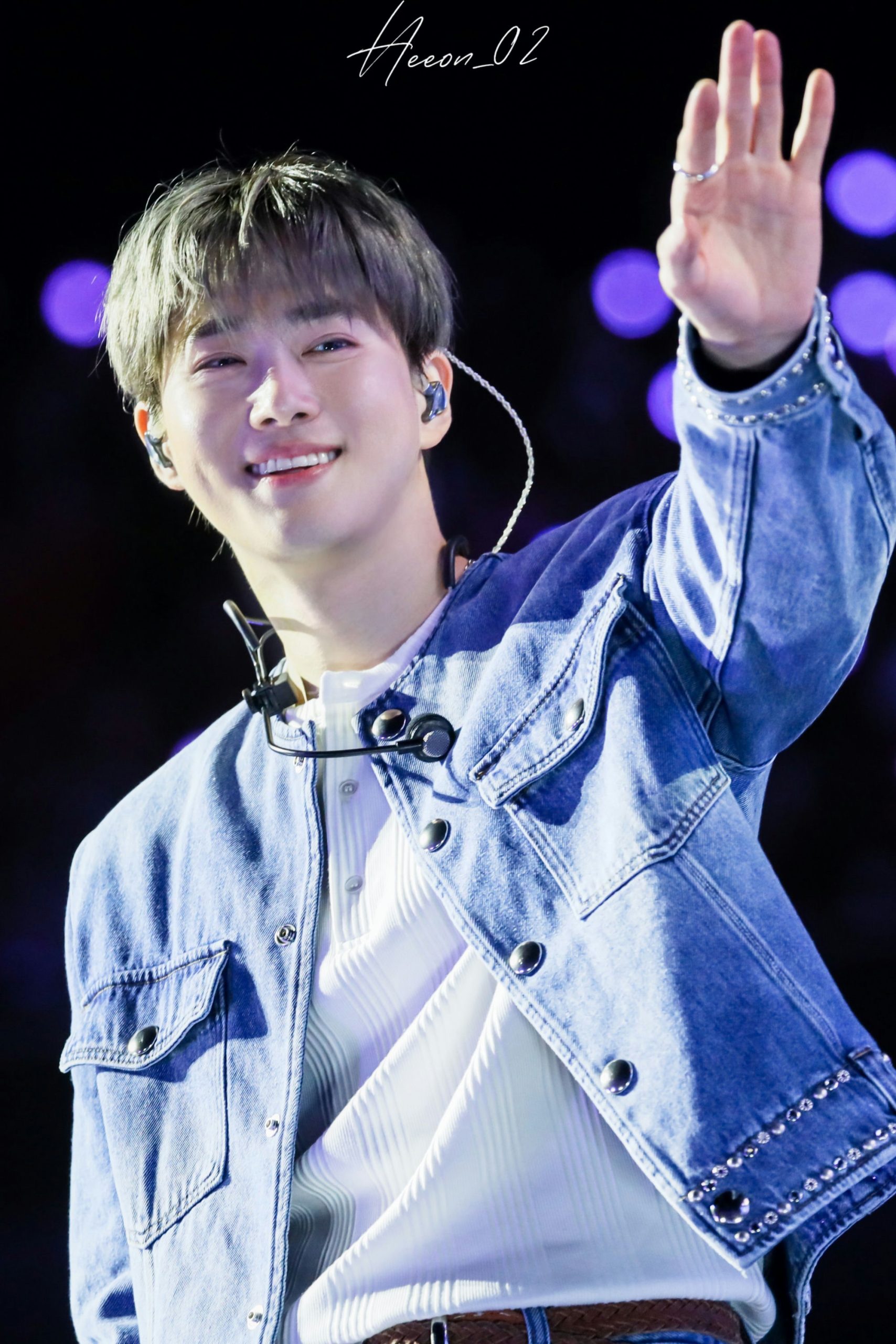 people-male performer-A-smiling-A-waving hand-A-denim jacket-B-in-ear monitor-C