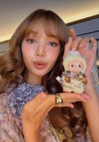 people-Lisa (BLACKPINK)-holding-plush toy-wearing-chunky ring-with-brown hair