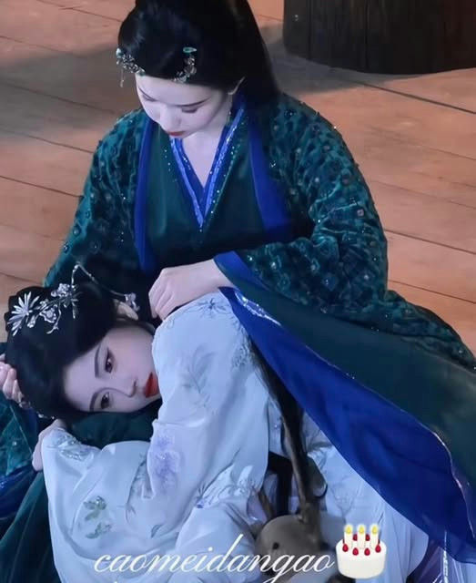 people-Two women-A-Chinese historical drama costume-A-Intimate embrace-A-Green and blue robes-A-White and light purple robes-A-Woman looking down tenderly-A-Woman resting head in lap
