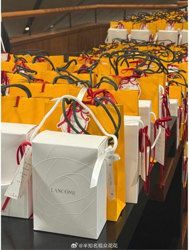 A large number of gift bags and boxes-A-cosmetic gifts-A-Lancome-A-Christmas/holiday theme-A-yellow and white-A-stacked display