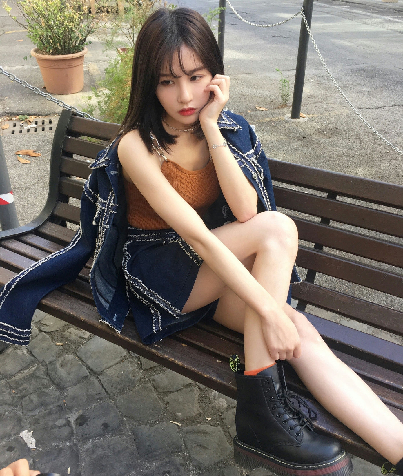 people-A-woman-A-sitting on bench-A-denim outfit-A-platform boots