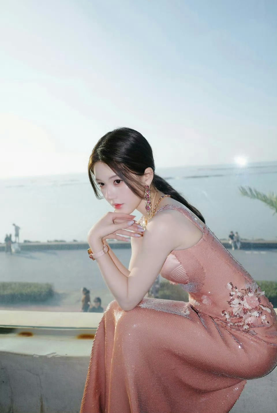 people-A-woman-A-pink sequin dress-B-ocean view-C-indoor lighting