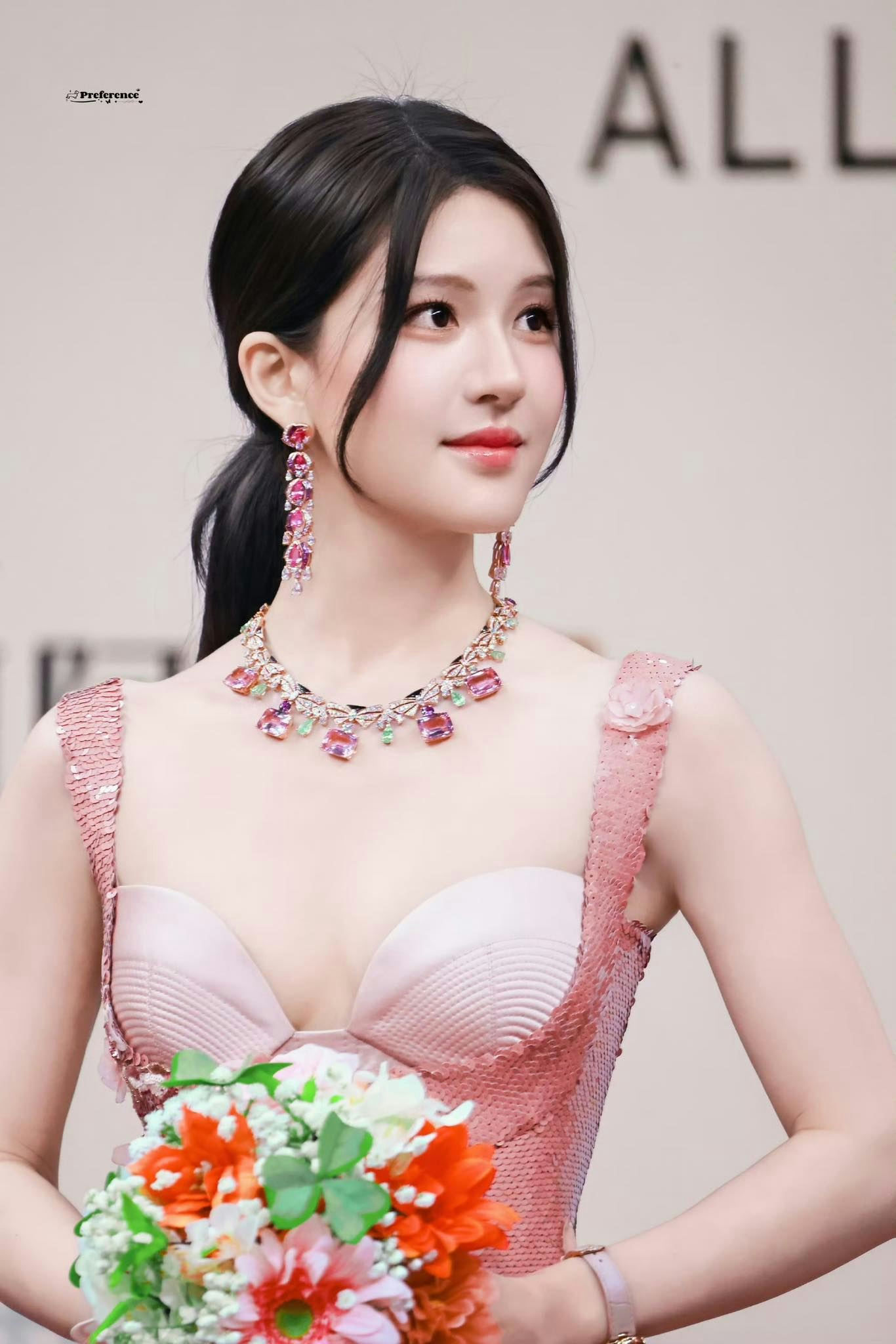 people-young woman-pink sequined dress-holding bouquet-ornate gemstone jewelry-high ponytail