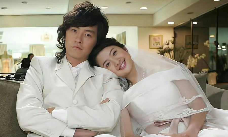 people-A-couple-A-wedding attire-A-man in white suit-A-woman in wedding dress-A-smiling bride-A-serious groom-A-Asian-B-indoor setting-C