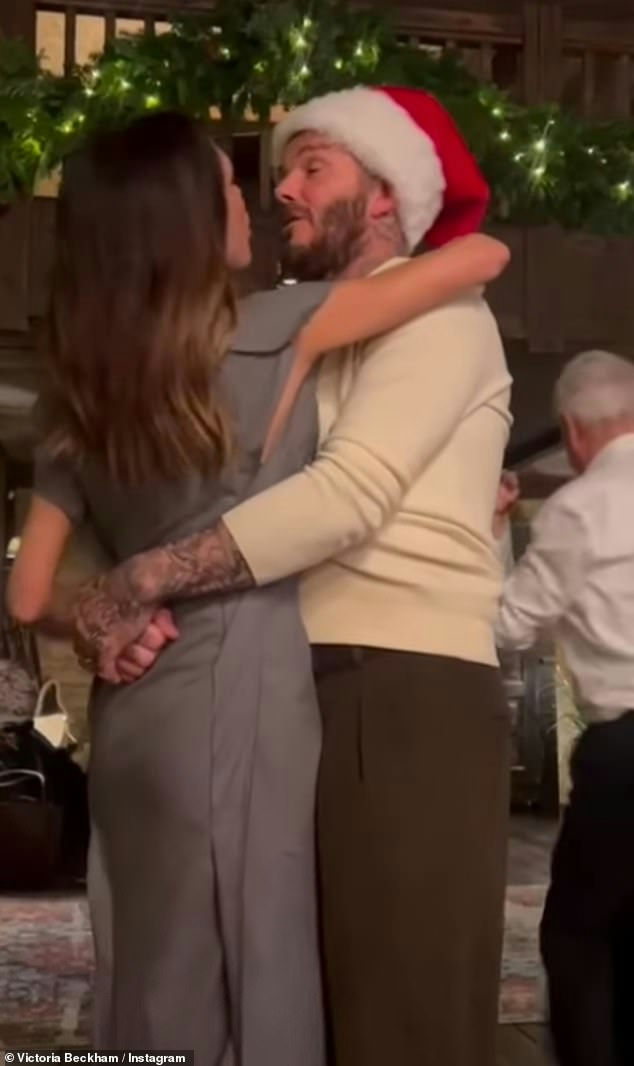 people-David Beckham-A-Santa hat-Victoria Beckham-A-grey dress-embrace-C-festive setting