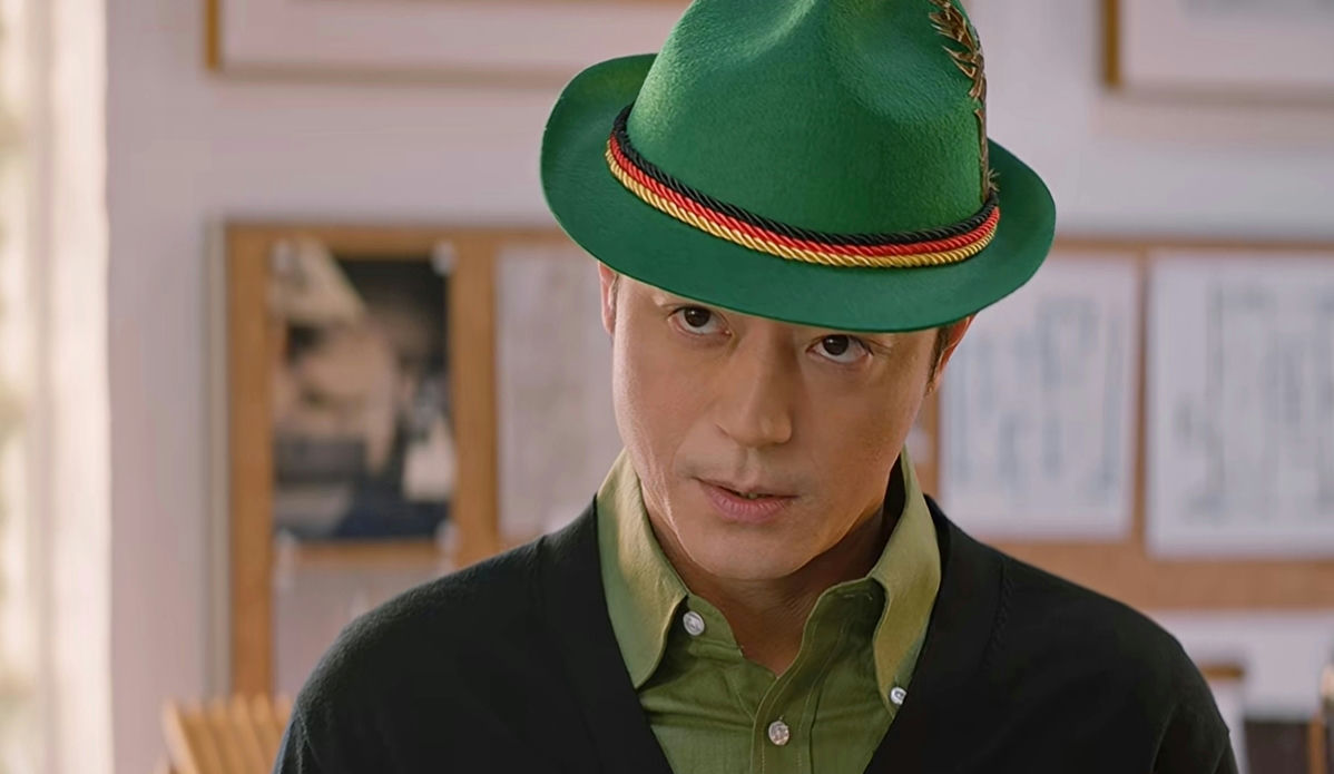 people-man-wearing-a-green-Alpine-hat-with-a-tricolor-cord-and-feather-accent-wearing-a-light-green-collared-shirt-and-a-dark-cardigan