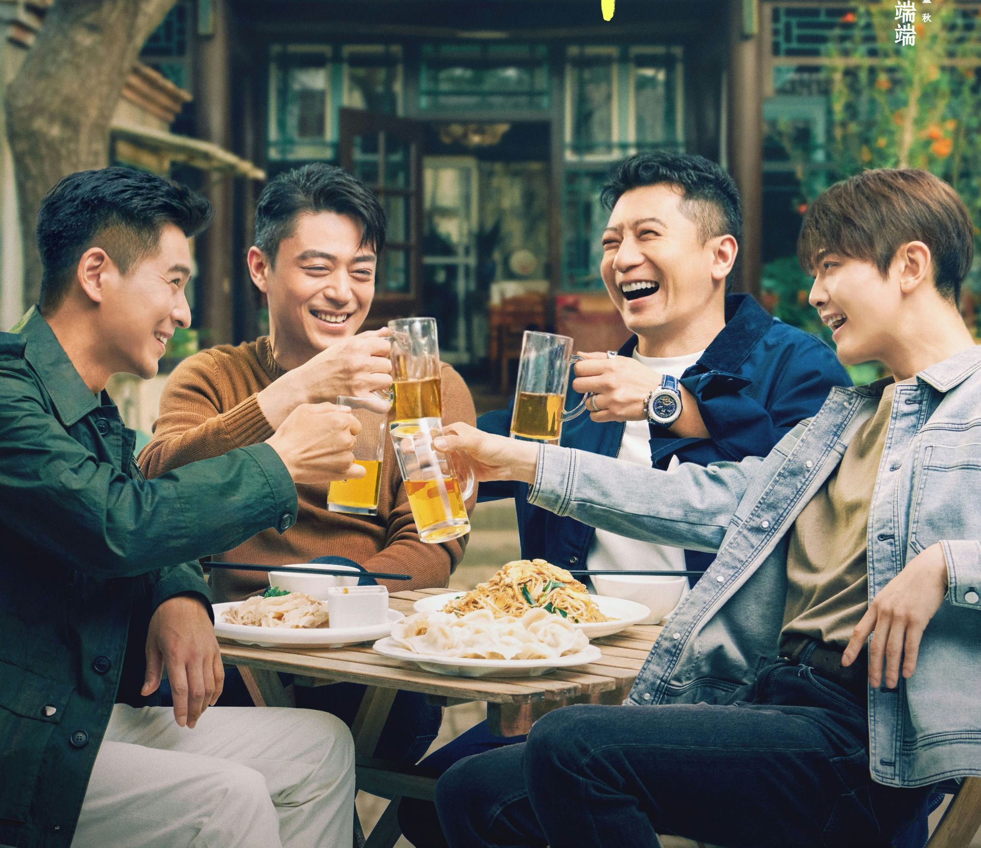 people-four men-A-drinking beer-A-toasting-A-smiling-A-eating food-B-sitting outdoors-B-laughing-C-casual clothing
