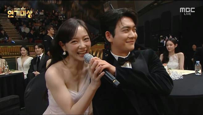 people-woman-smiling-microphone-man-formal wear-award ceremony