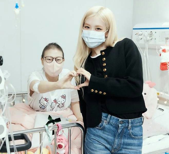 people-two women-A-hospital setting-A-heart hand gesture-A-face mask-B-celebrity visit-B-patient-C-blond hair-C