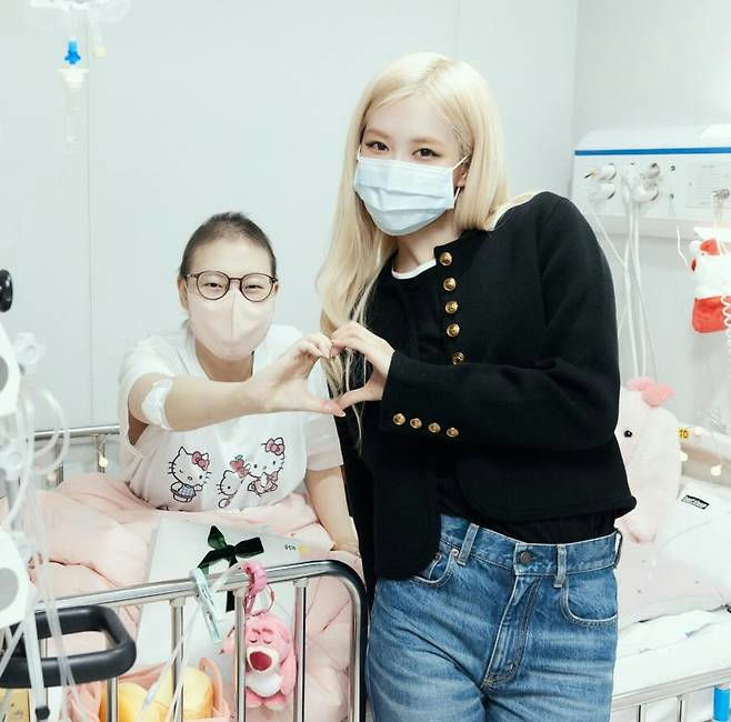 people-two women-A-hospital setting-A-heart hand gesture-A-face mask-B-celebrity visit-B-patient-C-blond hair-C