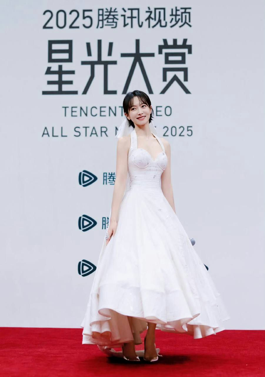 person-A-woman-A-white halter dress-A-short black hair-A-Tencent All Star Night 2025 backdrop