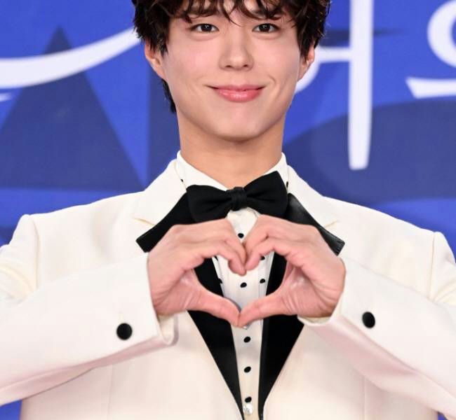 people-Park Bo-gum-male actor-heart hand gesture-white tuxedo-black bowtie-blue background
