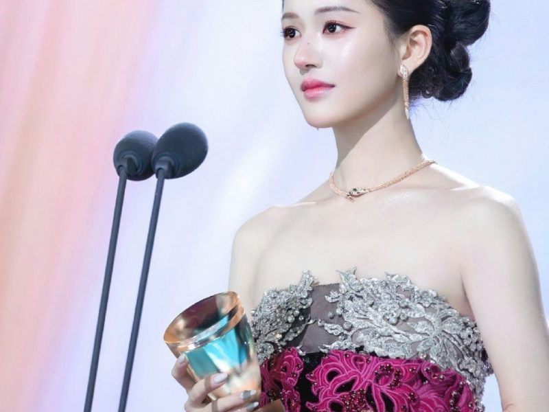 people-woman-A-award ceremony-B-holding trophy-C-elegant gown