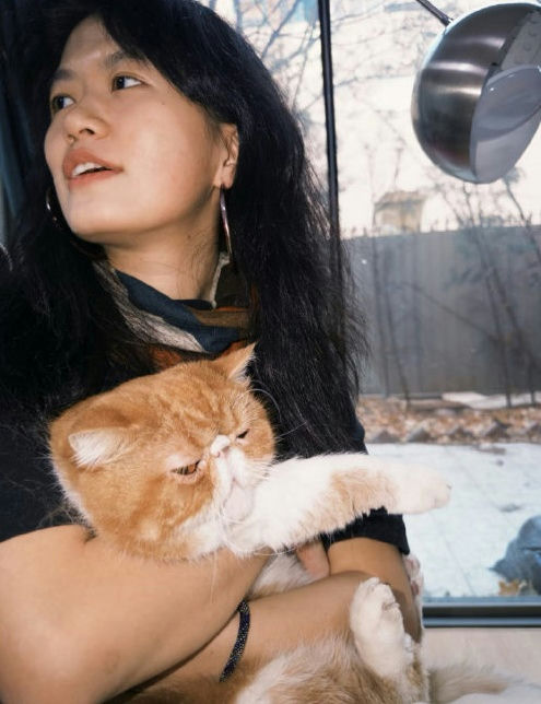 people-Asian woman-A-holding cat-A-Persian cat-A-indoors-A-looking away