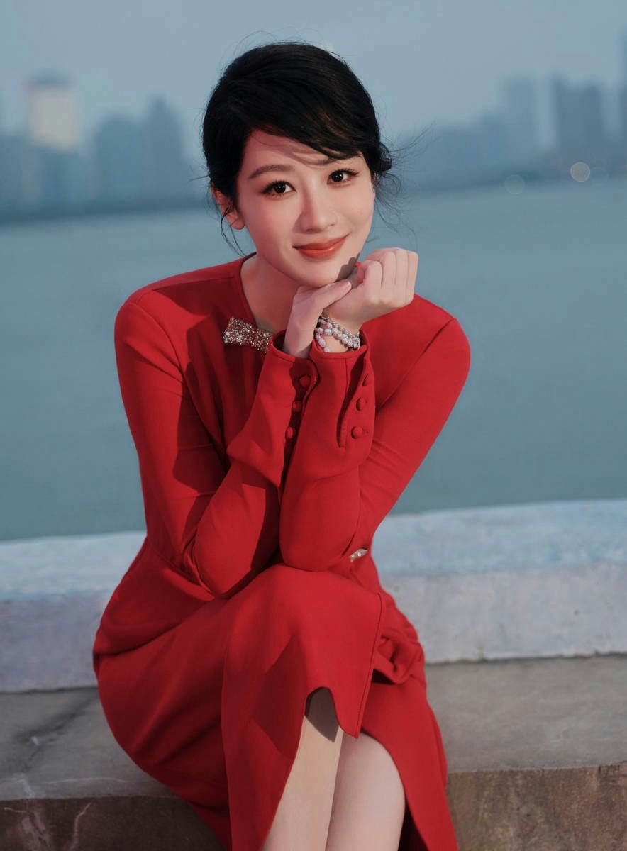 people-Chinese actress Jiang Shuying-red dress-A-pearl bracelet-A-sitting outdoors-A-bow brooch-A-cityscape background