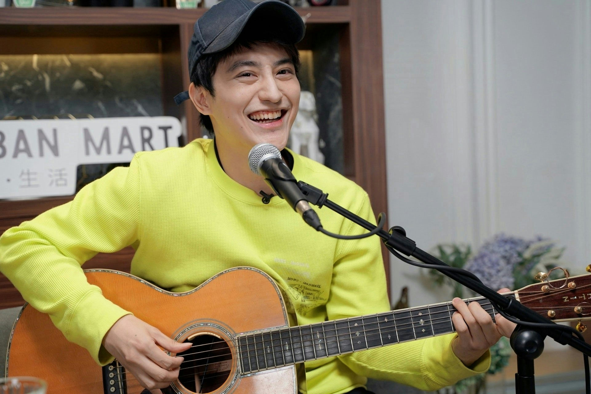 people-Masaaki Sakai-playing guitar-smiling-wearing cap-neon yellow shirt