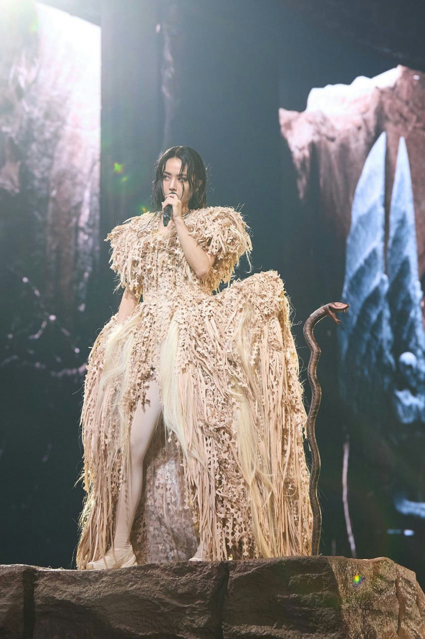 singer-A-elaborate costume-A-striking stage presence-A-dark hair-A-stage performance-B-snake prop-C-rock platform