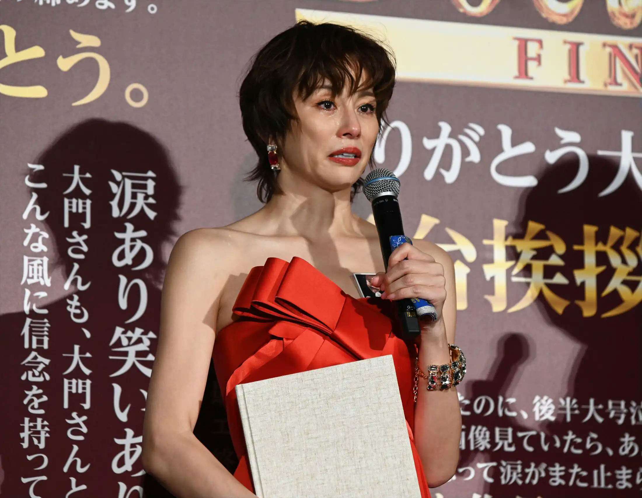 people-Ryoko Yonekura-A-crying-A-red strapless dress-A-holding a microphone-A-holding a book or album