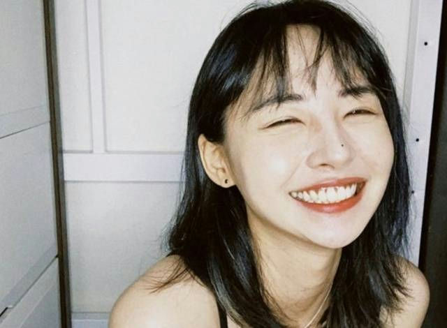 people-Woman-Smiling-A-Black hair-A-Closed eyes-A-Nose piercing-A-Black top