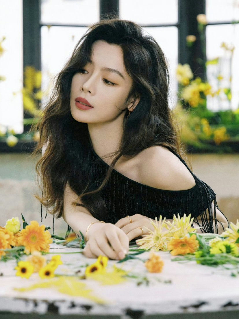 people-Niu Junjie-black top-A-yellow flowers-A-long dark wavy hair-A-leaning on table
