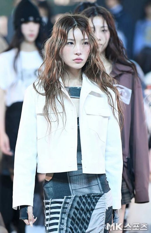 people-Jeon Somi-white cropped jacket-A-wavy brown hair-A-patterned grey and black outfit-A-fashion event