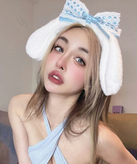 people-Asian woman-bunny ears headband-blue bow-light blue halter top-lip piercing-colored contacts