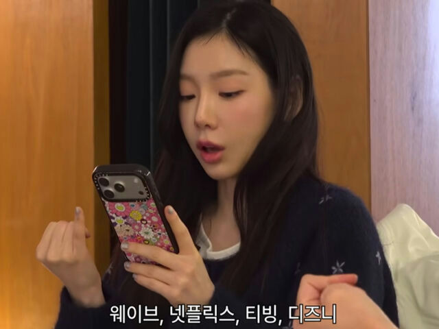 people-Taeyeon (Girls' Generation)-holding a phone-surprised expression-Korean text overlay