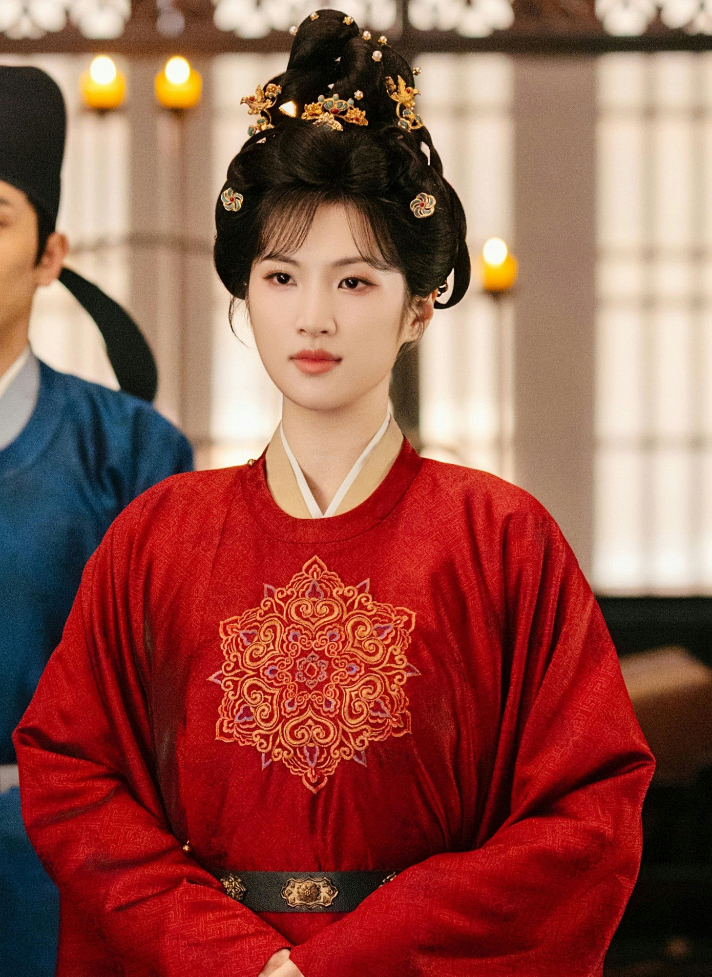 people-Chinese actress Zhao Lusi-red embroidered traditional dress-elaborate hair bun with gold ornaments-historical drama costume-indoor setting with warm lighting