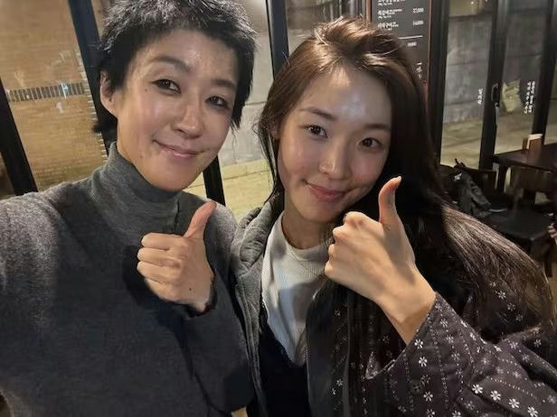 people-two women-selfie-thumbs up-short dark hair-long dark hair
