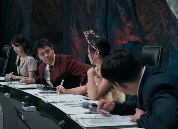 people-Kim Sung-soo-A-judging panel-A-sitting at table-B-writing-C-formal attire-D-dark background