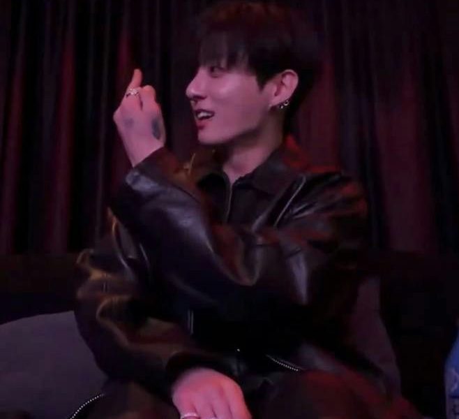 people-Jungkook (BTS)-black leather jacket-A-hand gesture (middle finger or similar)-A-dark background-A-rings on fingers