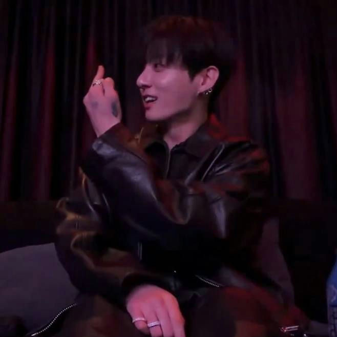 people-Jungkook (BTS)-black leather jacket-A-hand gesture (middle finger or similar)-A-dark background-A-rings on fingers
