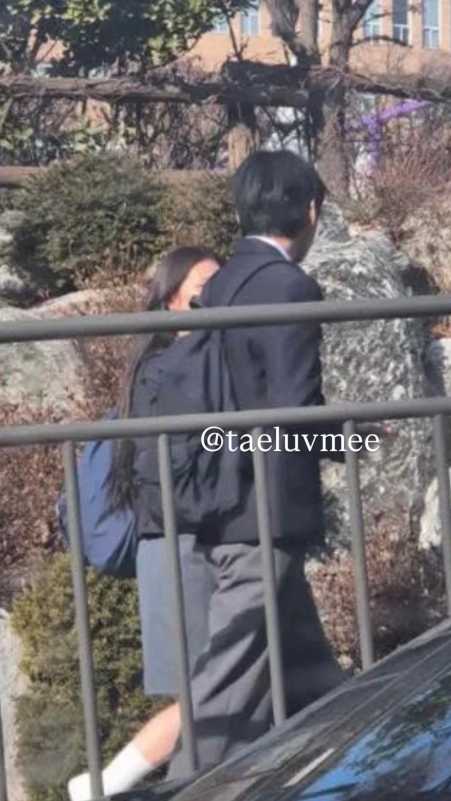 people-Two people walking outdoors-A-wearing school uniform-A-person partially obscured-B-person in dark suit-C-watermark "@taeluvmee"