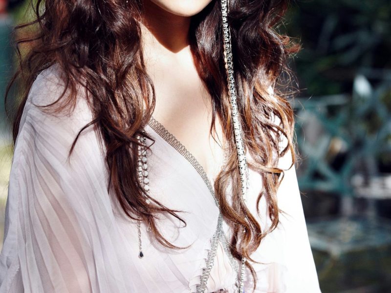 people-Selena Gomez-curly dark brown hair-A-dramatic eye makeup-A-pleated pale dress-B-long dangling earrings-C
