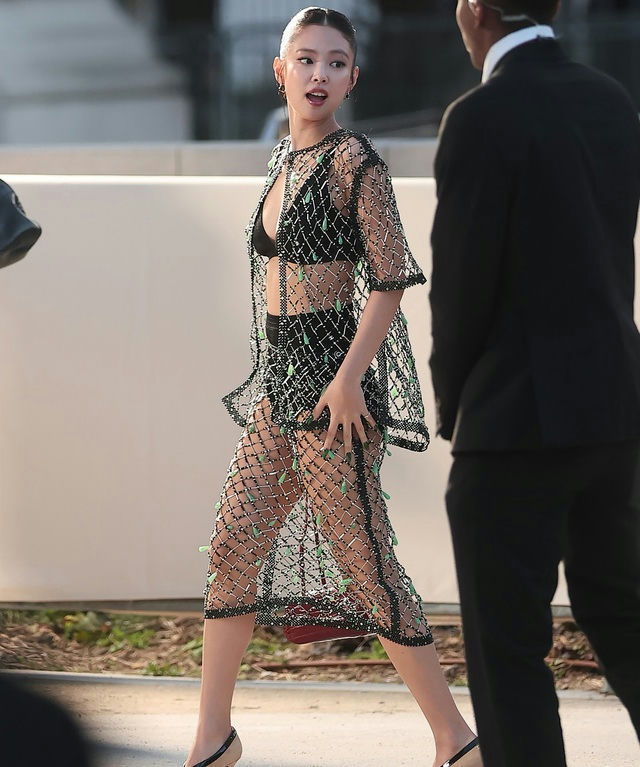 Jennie Kim-A-walking outdoors-A-sheer black dress-A-black bikini top and bottoms-A-security guard nearby