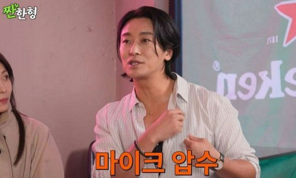 people-Nam Gyu-ri (likely) or another South Korean celebrity-Man speaking-Striped shirt-Black medium-length hair-Heineken branding in background