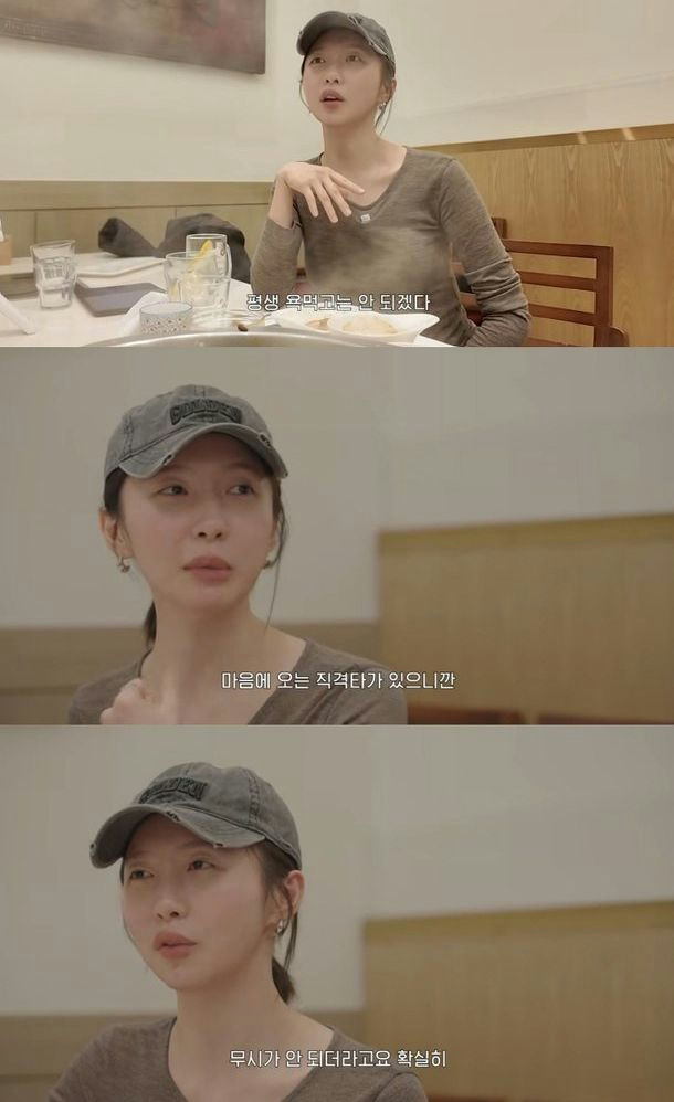 people-Han Ye-seul-sitting at a table-wearing a baseball cap-Korean subtitles-indoor setting