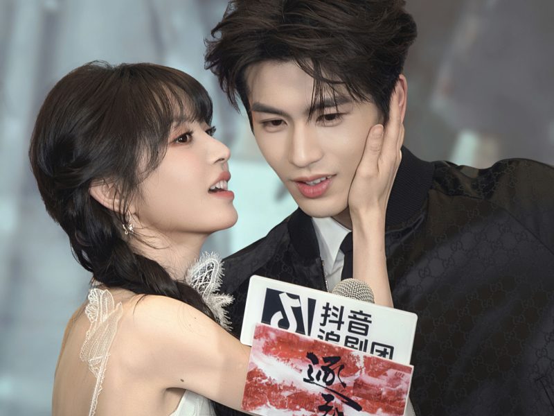 people-Bai Lu and Wang Hedi-intimate interaction-A-touching face-B-holding microphone sign-C-Gucci jacket